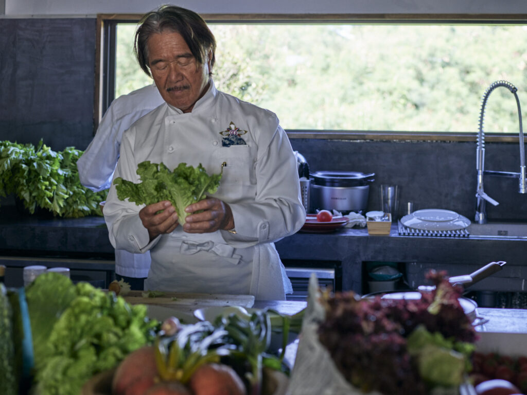 来間島の有機野菜を手に取る坂井宏行氏